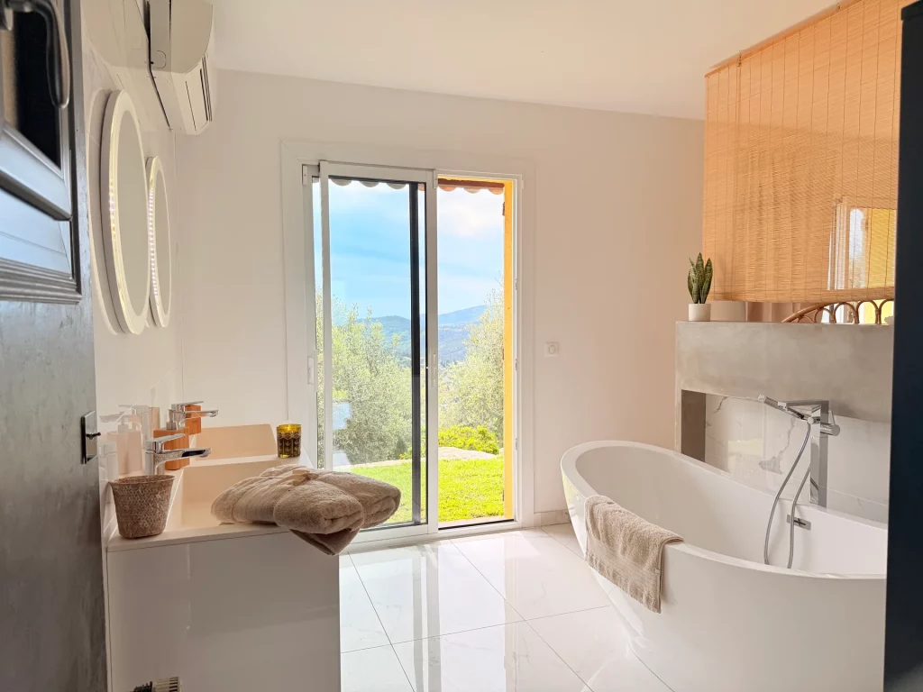 Salle de bain de luxe avec baignoire îlot et vue panoramique sur la baie de Cannes à la Villa Plen Souleù, Cabris.